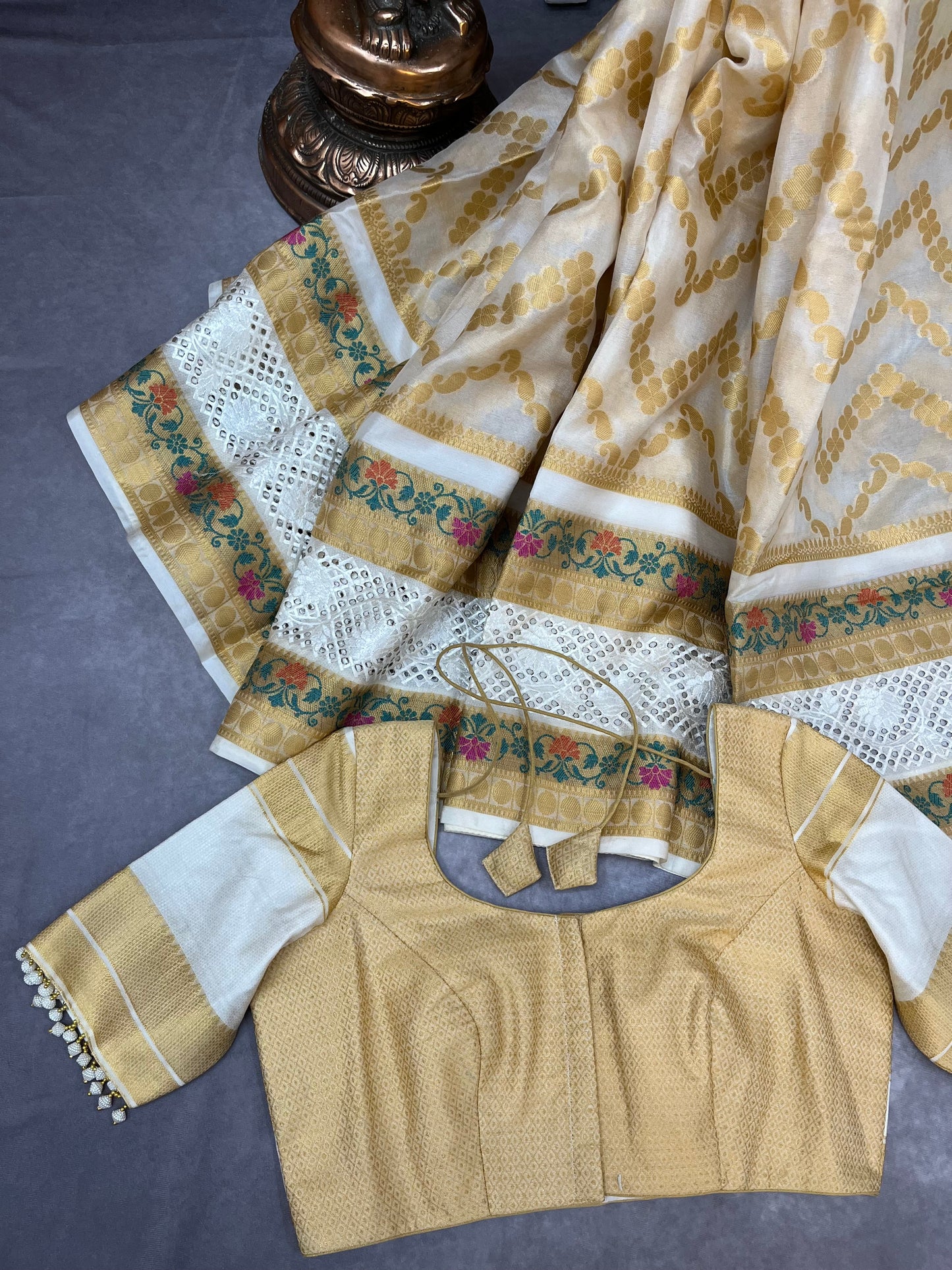 Off-white Banarasi saree adorned with mesmerizing meenakari and cutwork border