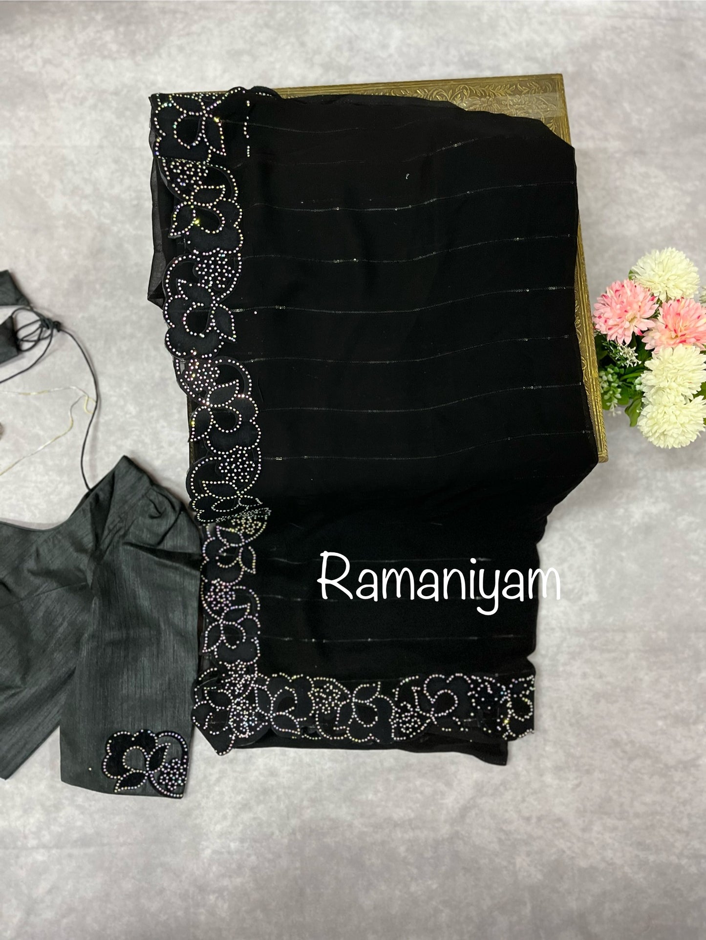 Party wear Black georgette saree featuring a beautiful cutwork border with crystal finishing